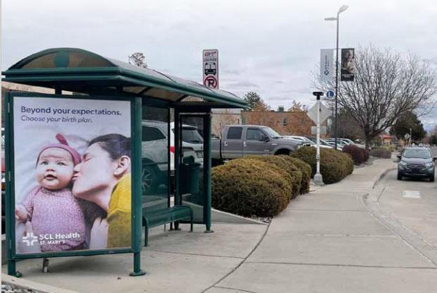 Photograph of Grand Valley Transit bus shelter with advertising poster for SCL Health.