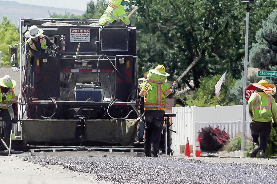 Road and Bridge crews apply chip seal to a county road using specialized equipment as part of Mesa County's annual pavement preservation program.